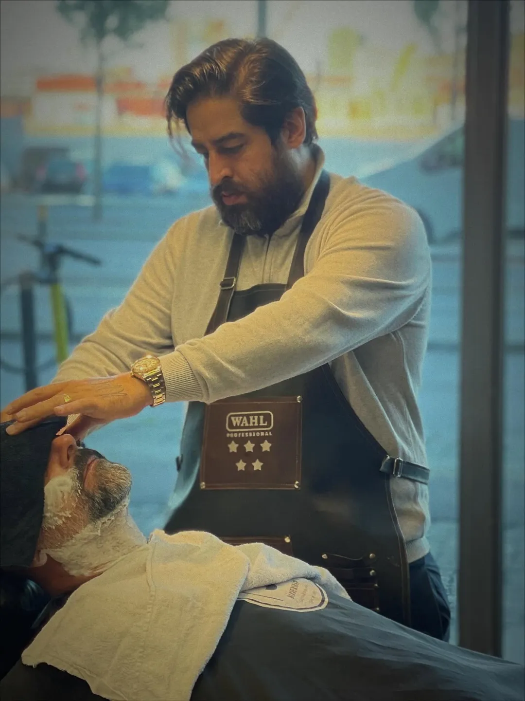 Barberare trimmar en kunds skägg