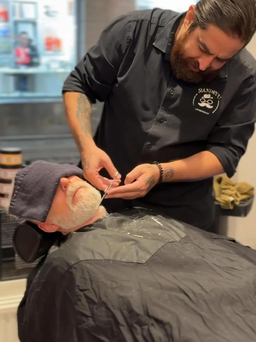 Barberare rakar en kund med kniv i salongen
